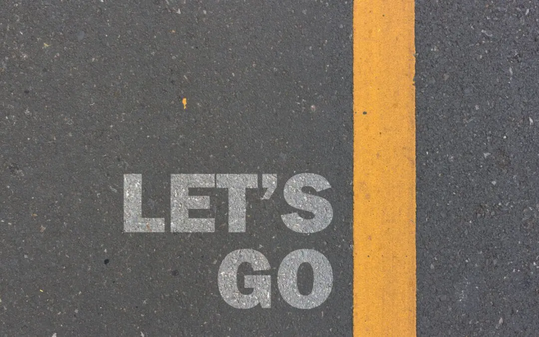 The word "let's go" painted on the side of a road.