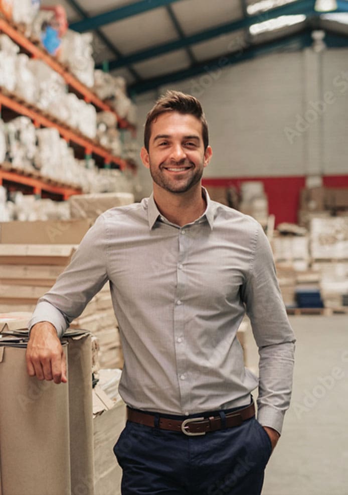 A smiling freelance web designer standing in a warehouse.